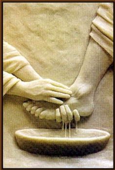 two hands touching the foot of a statue