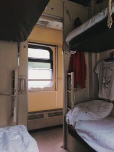 two bunk beds in a small room with windows