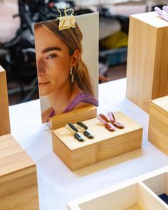 a table topped with wooden boxes filled with earrings