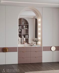 a white and pink bathroom with an arched mirror over the sink, along with shelves filled with books