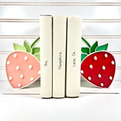 three bookends with two strawberries on them