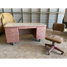 an old pink desk and chair in a garage