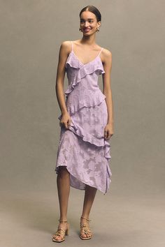 a woman in a purple dress posing for the camera