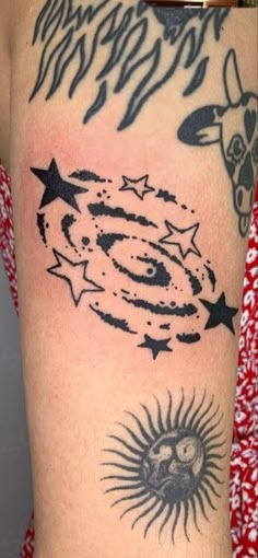 an arm with some tattoos on it and stars around the sun in black ink,