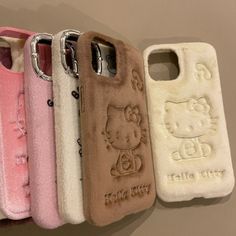 hello kitty phone cases are lined up in a row on the wall, one is pink and one is white