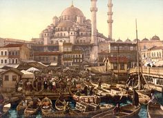 an old photo of people and boats in front of a large building with many spires