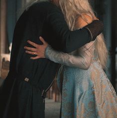 a man and woman embracing each other in an old fashion dress with long blonde hair