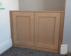 a wooden cabinet sitting on top of a carpeted floor next to a white wall