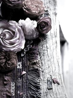 some flowers are sitting on top of a piece of old wooden plank that has been painted black and white