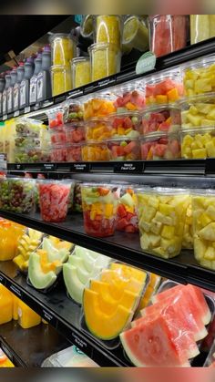 many different types of fruit are on display in a store aisle, including melons and watermelon