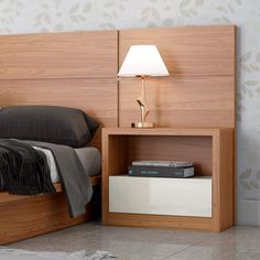 a bed with a wooden headboard and night stand next to a lamp on the nightstand