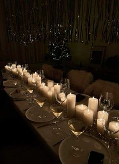 a long table is set with wine glasses and candles