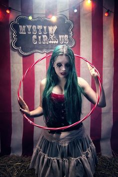 a woman with green hair is holding a hula hoop in front of an american flag