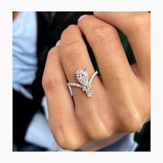 a woman's hand with a diamond ring on her finger and the other hand holding an engagement ring