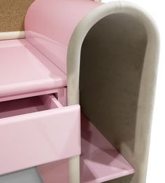 a pink and white children's bed with two drawers