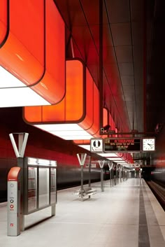 an empty train station with red and white lights