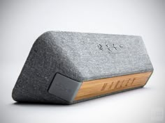 an image of a speaker with wood in the front and grey fabric on the back