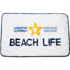 a bath mat with the words beach life written on it in blue, yellow and white