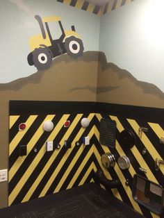 there is a construction theme on the wall in this kids's playroom area