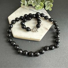 This Stunning Piece Is Hand Knotted And Features Faceted Natural Stones That Catch The Light Beautifully. The Black Onyx Beads Are Sleek And Sophisticated, Making This Necklace Perfect For Dressing Up Any Outfit. Whether You're Heading To A Fancy Event Or Just Want To Add Some Glam To Your Everyday Look, This Necklace Is Sure To Do The Trick. So Why Wait? Treat Yourself To This Gorgeous Piece Today! 10mm Faceted Black Onyx. Stainless Steel Sailor Clasp, Removable Pendant Can Be Added. Black Necklaces With Round Natural Stones, Elegant Adjustable Black Crystal Necklace, Formal Black Onyx Necklace, Black Onyx Round Bead Crystal Necklaces, Black Onyx Round Beads Necklace, Black Onyx Round Beads Crystal Necklace, Black Onyx Necklaces With Faceted Beads, Black Onyx Necklace With Faceted Beads, Elegant Black Round Bead Crystal Necklaces