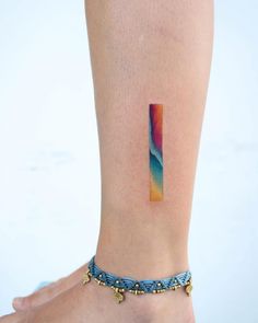 a woman's foot with a colorful tattoo on her left ankle and the bottom part of her leg