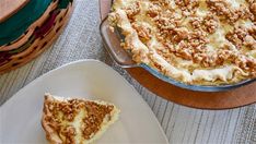 a piece of pie sitting on top of a white plate next to a wooden basket