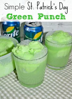 three glasses filled with green punch sitting on top of a table next to cans of soda