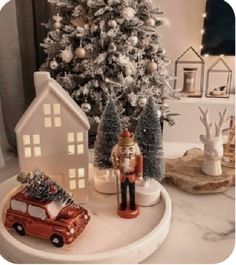 a nutcracker is standing next to a christmas tree and a toy car in front of it