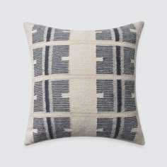 a black and white pillow with an abstract pattern on the front, sitting on a gray background