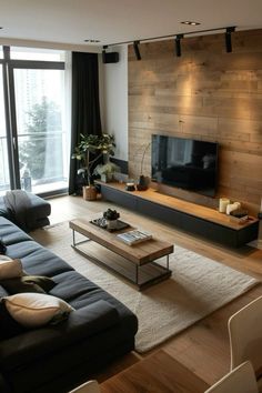 a living room filled with furniture and a flat screen tv on top of a wooden wall