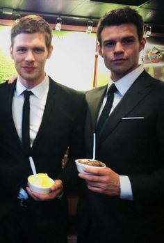 three men in suits and ties holding bowls of food