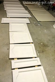 several pieces of white cabinet doors laying on the floor