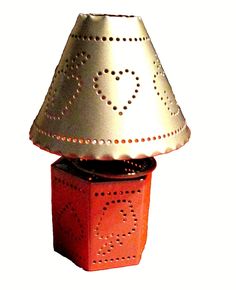 a lamp that is sitting on top of a red box with holes in the middle