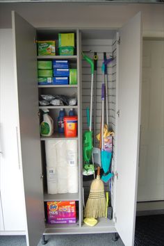 an open cabinet with cleaning supplies and brooms