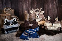 several crocheted stuffed animals sitting next to each other on a rug in front of a wooden wall