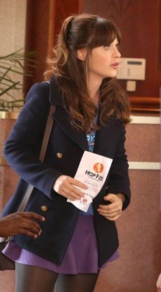 a woman standing in front of a man holding a book