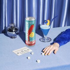 a blue table topped with a can of soda and dice