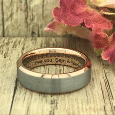 two wedding bands with the words i love you sam and mark engraved on them next to flowers