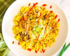 a white plate topped with rice and veggies on top of a green napkin