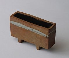 a small clay planter sitting on top of a white table