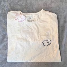 New With Tags * Never Worn * Ivory Ella * White T-Shirt * Pocket W/ Elephant On The Front * Ivory Ella Lettering And Pink Elephant On Back Dark Purple Logo, Ivory Ella Shirts, Paisley Elephant, Elephant Shorts, Elephant Shirt, Teal Shorts, Ivory Ella, Shirt Pocket, Yellow T Shirt