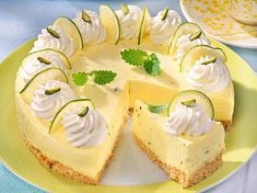 a cheesecake with cucumbers and whipped cream on top sits on a yellow plate