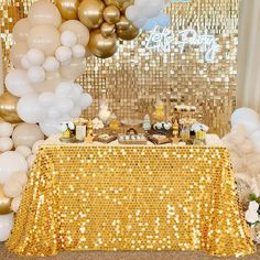 a table with gold sequins and white balloons