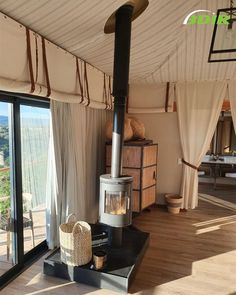 an open living room with a wood stove in the center and sliding glass doors leading outside