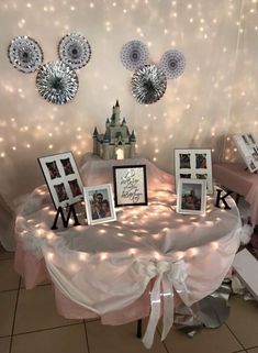 the table is set up with pictures and lights on it for an event or party