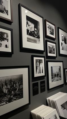 black and white photographs hanging on the wall next to each other in a room with dark walls