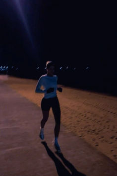 a man running down a sidewalk at night with the sun shining on his shirt and shorts