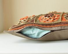 an orange and brown purse sitting on top of a white table