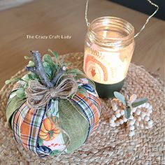 a glass jar sitting on top of a table next to a pumpkin