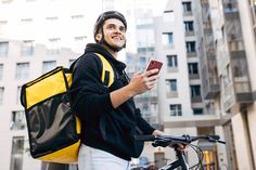 Portrait of delivery man holding a mobile phone, wearing thermal backpack standing against apartment building Delivery Boy, Sales People, Iphone Shop, Apartment Building, Delivery Man, Graphic Design Posters, Shopping Mall, Mobile Phone, Photoshop